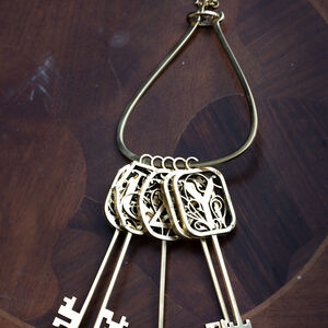 Brass lyre-shaped keyring “Keys and Symbols”